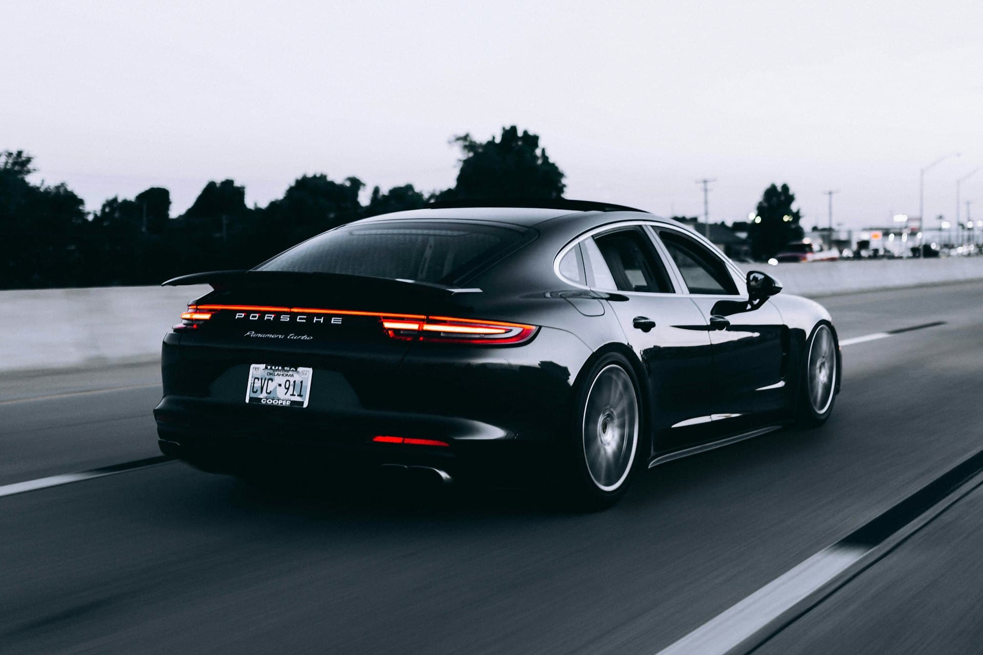 A dark performance sedan photographed at dusk, the finish catching low light.